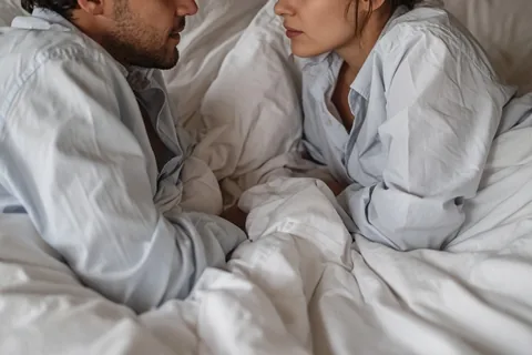 Illustration for Man and woman in shirts in bed